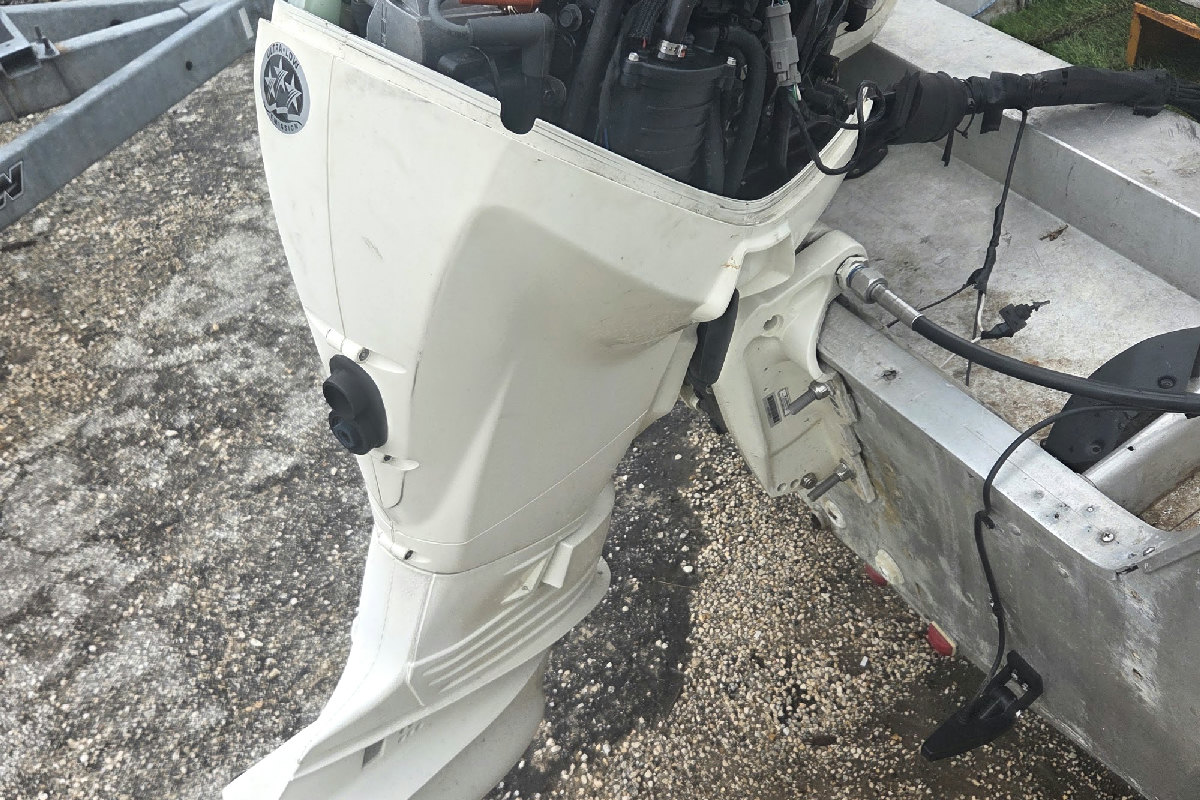 An outboard boat motor mounted on a stand in a workshop.